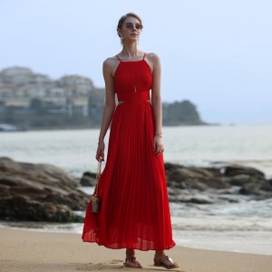 Maxi vestido vermello plisado na praia do mar