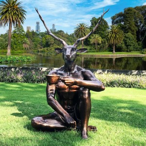 Mitološki bronasti kip DeerMan v naravni velikosti, ki ljubi svojo kavo