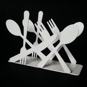 Laual kasutage musta valget roosat sinist metallist kahvleid ja noakujulist salvrätikuhoidjat