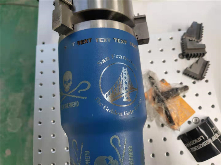 La màquina de marcatge làser de fibra elimina la pintura del tub metàl·lic amb mandril rotatiu