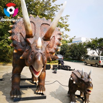Mãe e filho dinossauro triceratops aparecem em um parque temático de dinossauros